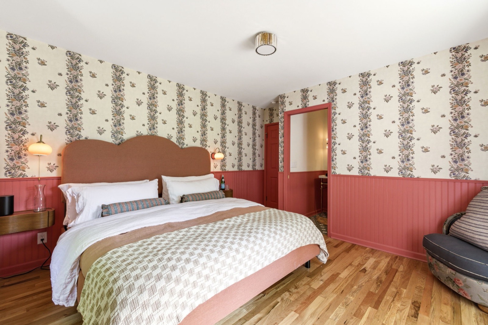 The Rose Suite: king bed with a scalloped rose headboard and beadboard walls