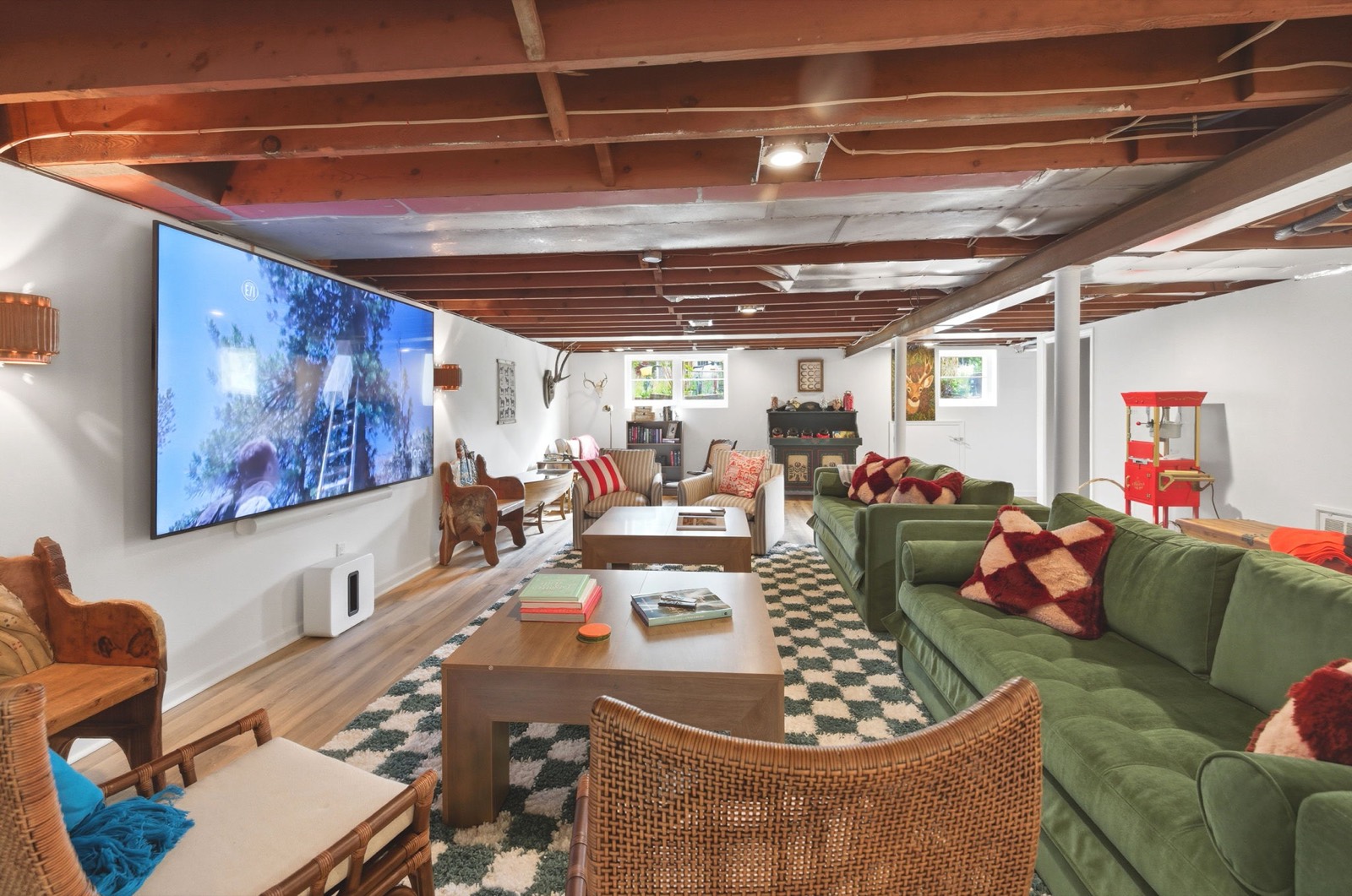The lower-level theater and game room with a 100-inch screen and matching sleeper sofas